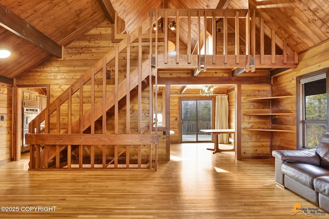 living area featuring wood finished floors, high vaulted ceiling, wood walls, wooden ceiling, and beamed ceiling