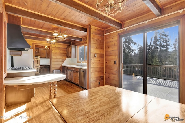 kitchen with wooden walls, extractor fan, a chandelier, wood ceiling, and light wood-type flooring