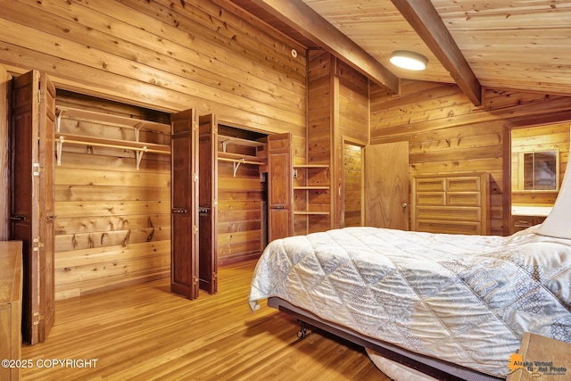 bedroom with wood ceiling, lofted ceiling with beams, wooden walls, and light wood-style flooring