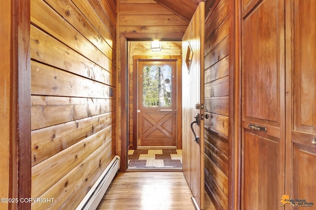 entryway featuring wood walls, light wood-style flooring, and lofted ceiling