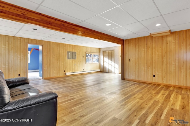 living area featuring light wood-style flooring, a paneled ceiling, baseboards, and a baseboard radiator