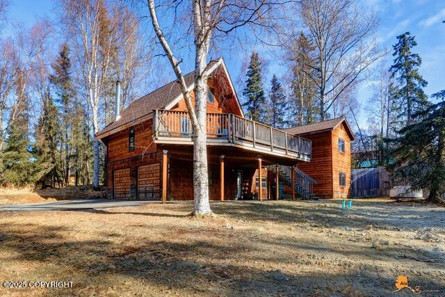 view of front of home with a deck, stairway, and a garage