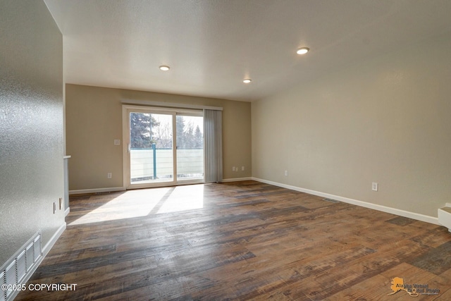 spare room with dark wood-style floors, baseboards, and recessed lighting