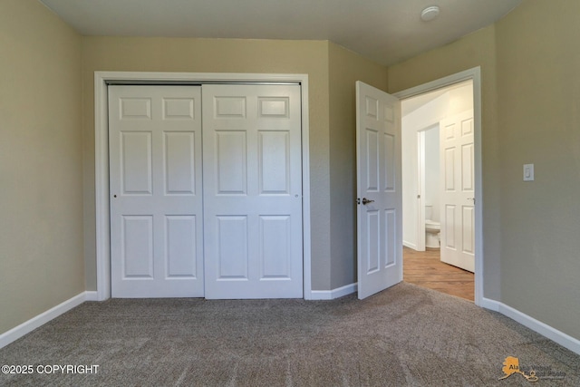 unfurnished bedroom featuring carpet, baseboards, and a closet