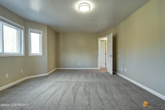 unfurnished room featuring carpet and baseboards