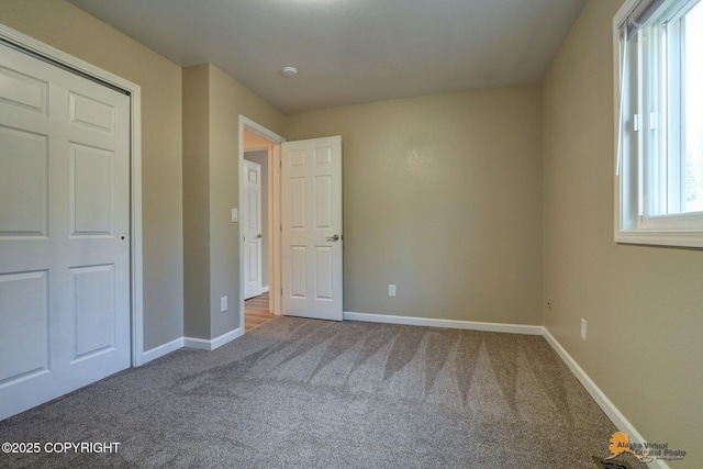 unfurnished bedroom featuring carpet flooring and baseboards