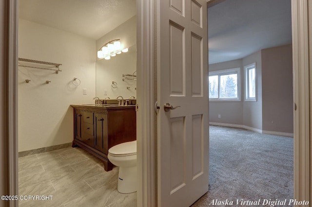 bathroom with vanity, baseboards, and toilet