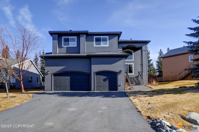 view of front facade featuring an attached garage, driveway, and fence