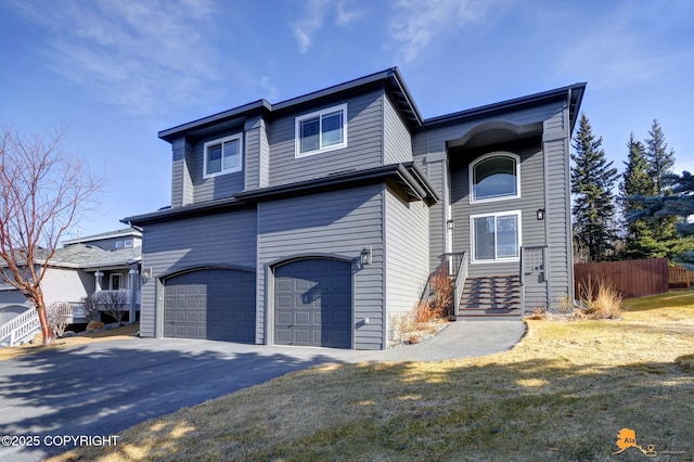 view of front of property with driveway, a garage, and fence