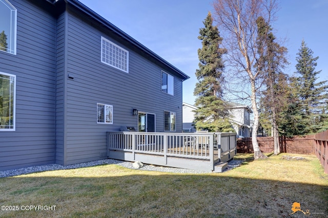 rear view of property featuring a lawn, a fenced backyard, and a wooden deck