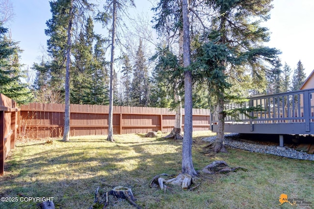 view of yard with a deck and fence