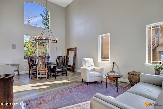 living area featuring a high ceiling, wood finished floors, and baseboards