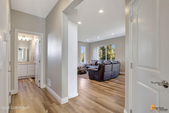 hall with visible vents, recessed lighting, baseboards, and light wood-style floors