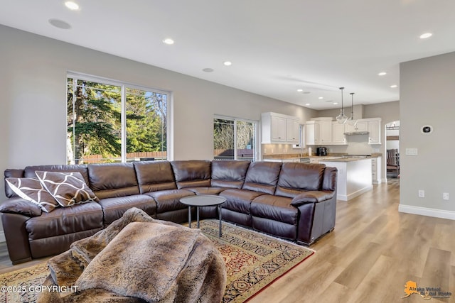 living area featuring recessed lighting, light wood-type flooring, and baseboards