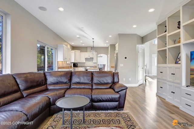 living area with recessed lighting, baseboards, and light wood finished floors