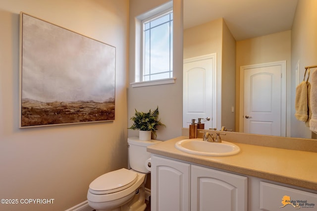 half bathroom with toilet and vanity