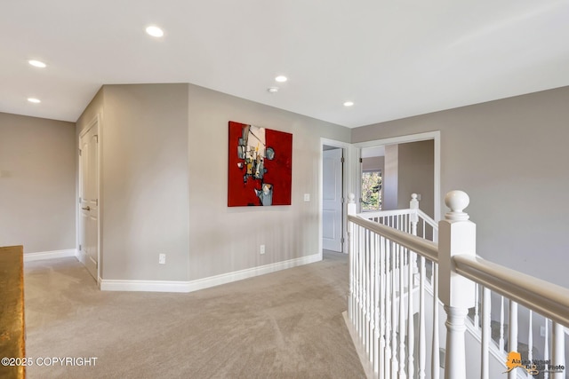 hallway with recessed lighting, baseboards, an upstairs landing, and light carpet