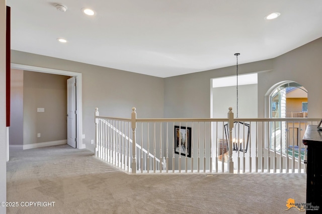 hall with an inviting chandelier, carpet flooring, recessed lighting, and baseboards