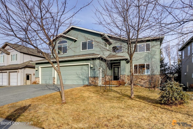 view of front facade with stone siding, driveway, an attached garage, and a front yard