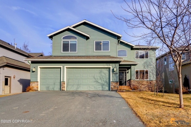 view of front of house featuring stone siding, driveway, and a garage