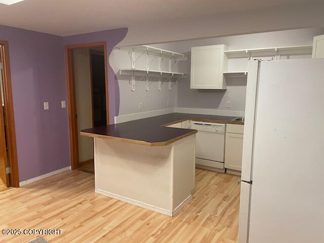 kitchen with dark countertops, light wood-style flooring, white appliances, white cabinetry, and open shelves