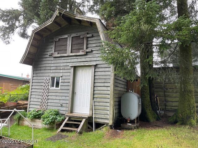 view of outbuilding with fence, an outbuilding, and entry steps