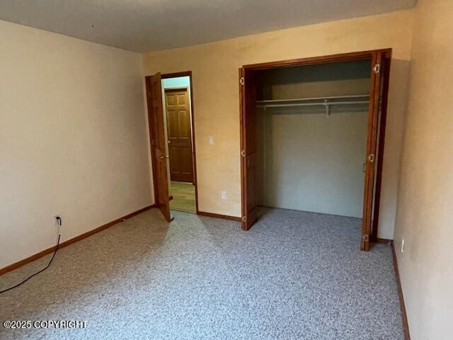 unfurnished bedroom with carpet flooring, baseboards, and a closet