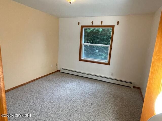 empty room featuring carpet, baseboards, and baseboard heating