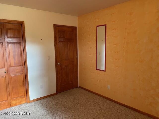 unfurnished bedroom featuring carpet flooring, baseboards, and a closet