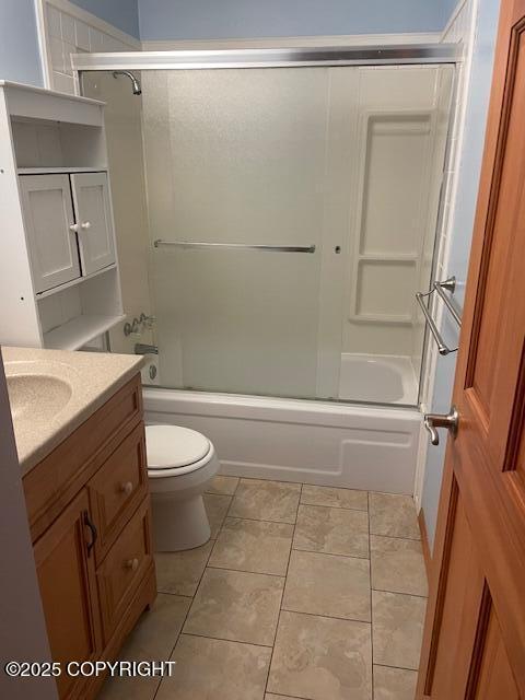 bathroom featuring vanity, tile patterned floors, toilet, and enclosed tub / shower combo