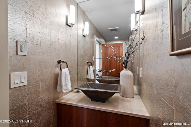 1665 Bob Atwood Cir, Anchorage, AK 99517 - bathroom with visible vents, vanity, and tile walls