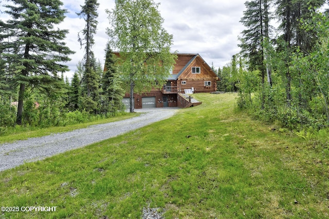 view of yard featuring gravel driveway and a garage