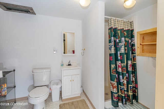 bathroom with a shower stall, toilet, vanity, and baseboards