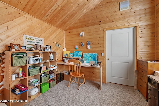 home office featuring vaulted ceiling, visible vents, carpet floors, and wood walls