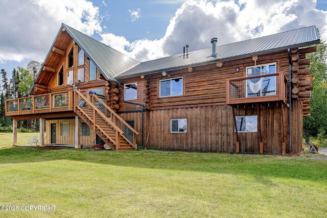 rear view of house with stairway, a wooden deck, log siding, a yard, and metal roof