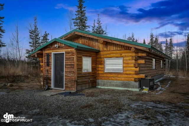 view of front of property featuring log siding, board and batten siding, and metal roof