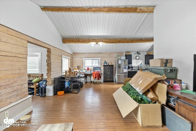 interior space featuring stainless steel fridge with ice dispenser and wood walls