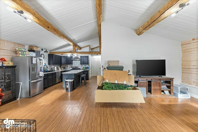 living room with wooden walls, vaulted ceiling with beams, and light wood-type flooring