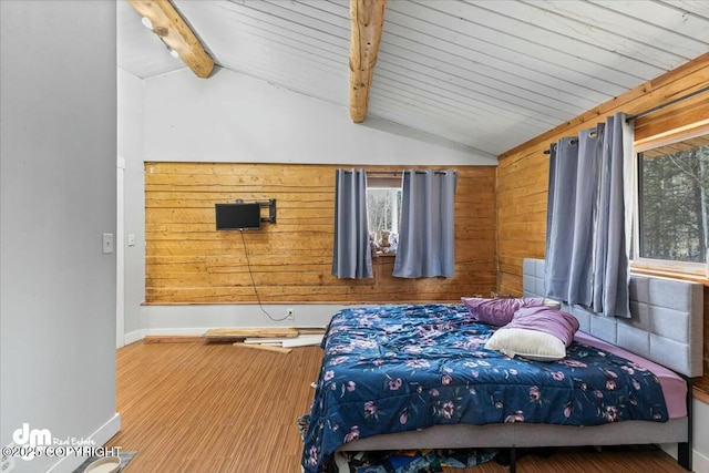 bedroom with multiple windows, wood finished floors, and vaulted ceiling with beams