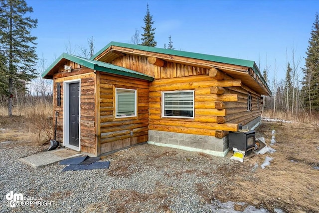 view of front of home featuring log siding and metal roof