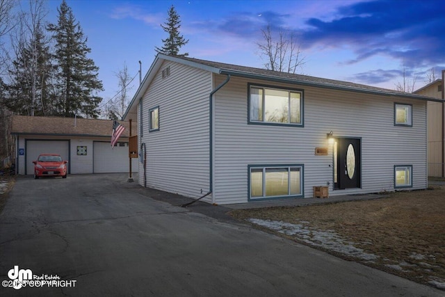 bi-level home with an outdoor structure and a garage