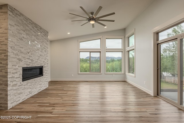 9475 E Spring Creek Cir, Wasilla, AK 99654 - unfurnished living room featuring ceiling fan, a stone fireplace, wood finished floors, recessed lighting, and baseboards