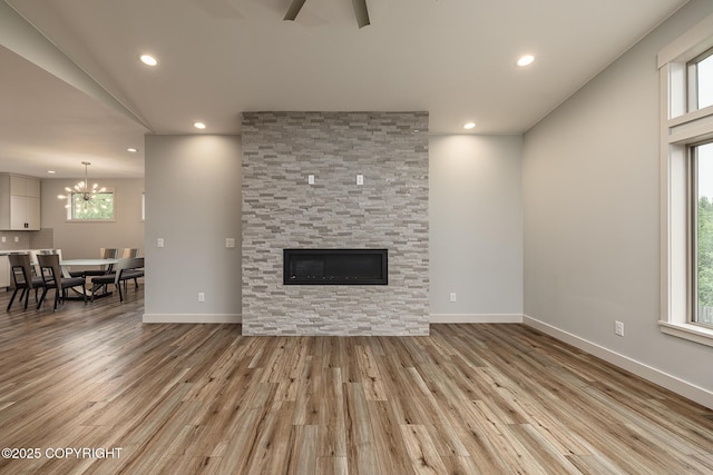 9475 E Spring Creek Cir, Wasilla, AK 99654 - living area with light wood-style floors, recessed lighting, a chandelier, ceiling fan, and a stone fireplace