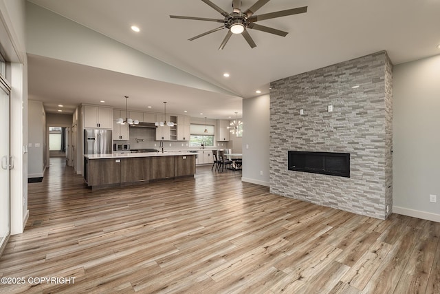 9475 E Spring Creek Cir, Wasilla, AK 99654 - living room featuring a ceiling fan, recessed lighting, light wood finished floors, lofted ceiling, and a fireplace