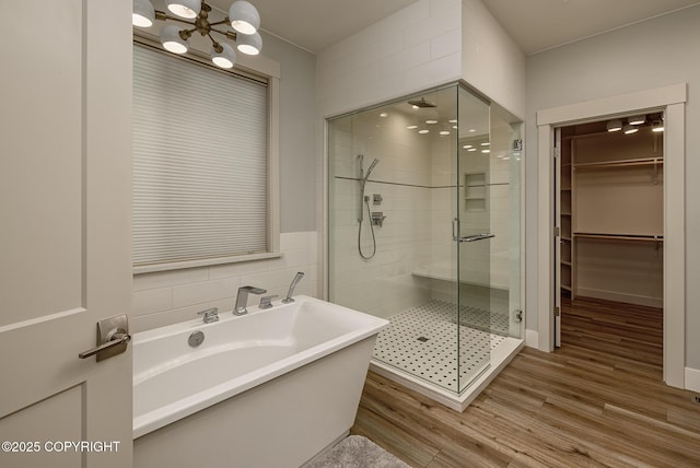 9475 E Spring Creek Cir, Wasilla, AK 99654 - full bathroom featuring a freestanding tub, a shower stall, a chandelier, and wood finished floors