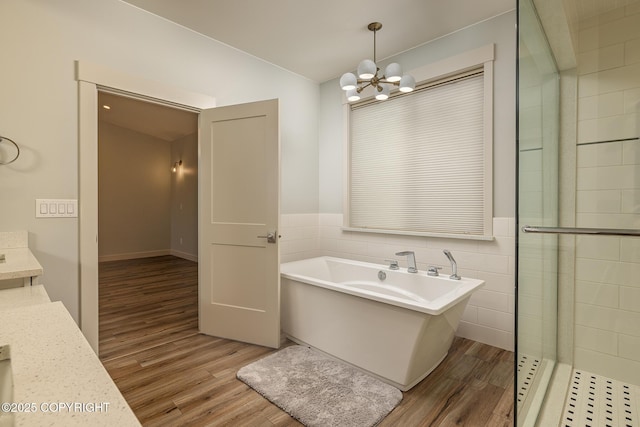 9475 E Spring Creek Cir, Wasilla, AK 99654 - full bathroom with wood finished floors, a freestanding bath, a chandelier, vanity, and wainscoting