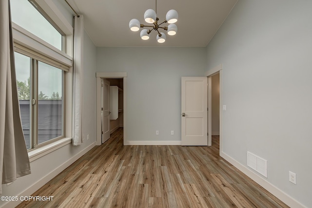 9475 E Spring Creek Cir, Wasilla, AK 99654 - empty room featuring a chandelier, wood finished floors, and baseboards