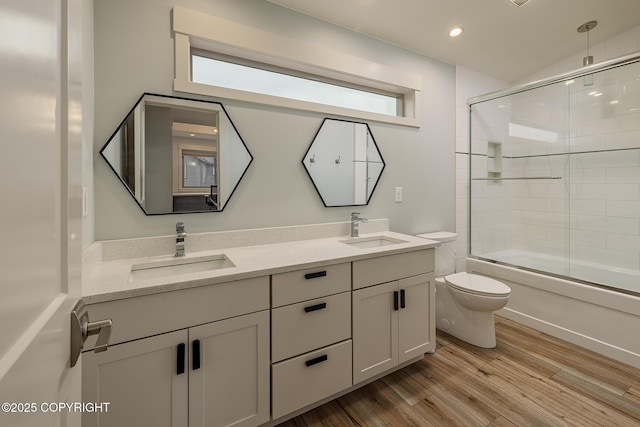 9475 E Spring Creek Cir, Wasilla, AK 99654 - full bath featuring toilet, double vanity, enclosed tub / shower combo, wood finished floors, and recessed lighting