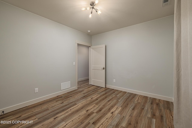 9475 E Spring Creek Cir, Wasilla, AK 99654 - unfurnished room with wood finished floors, baseboards, a smoke detector, and a chandelier