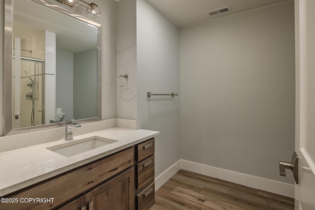 9475 E Spring Creek Cir, Wasilla, AK 99654 - bathroom with vanity, wood finished floors, a shower stall, and baseboards